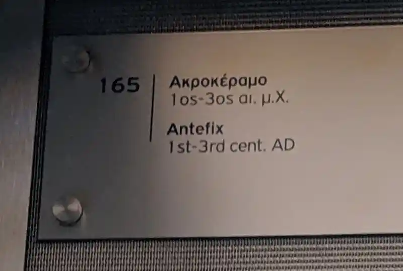 Roman period terracotta antefix from Attica depicting a bust of goddess Athena framed by floral motifs and topped by a palmette. 